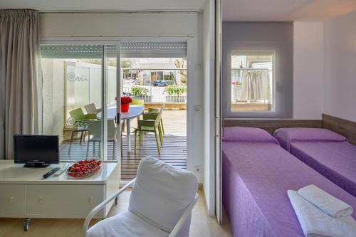 a bedroom with a purple bed and a table and chairs at Apartamentos Centremar in L'Estartit