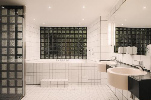 a white bathroom with two sinks and a window at Scandic Lillehammer Hotel in Lillehammer