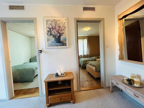 a living room with a mirror and a bedroom at Cozy Home - Holiday, Sleepover in Rødbyhavn