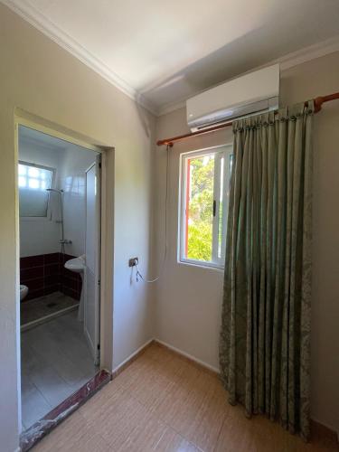 a bathroom with a shower curtain and a window at Top view hostel in Durrës