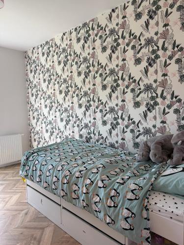 a bedroom with a bed with a floral wallpaper at Apartament Krisa z ogródkiem in Pogórze
