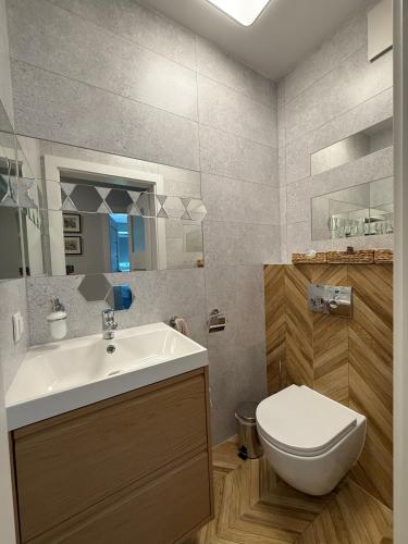 a bathroom with a white sink and a toilet at Apartament Krisa z ogródkiem in Pogórze