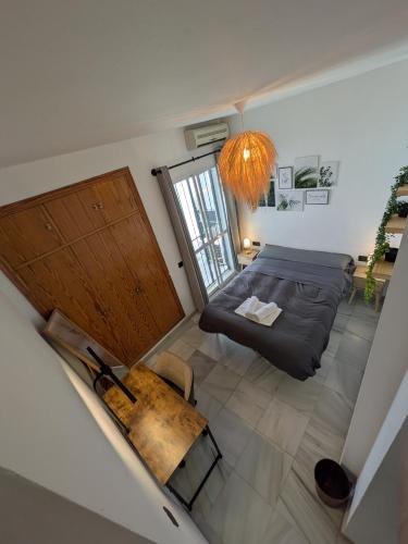 a room with a bed and a table and a window at Vincents Paradise in Mairena del Aljarafe