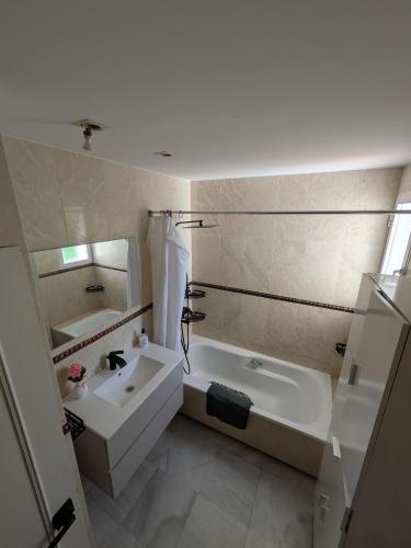 a bathroom with a tub and a sink and a bath tub at Vincents Paradise in Mairena del Aljarafe