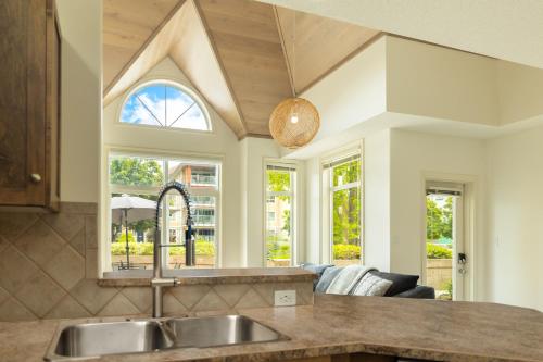 a kitchen with a sink and some windows at sunset 101 in Kelowna