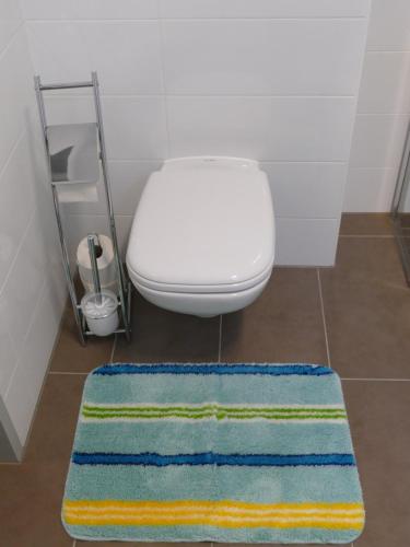 a bathroom with a toilet and aicolored rug at Chads City Apartment mit Tiefgarage free parking in Graz