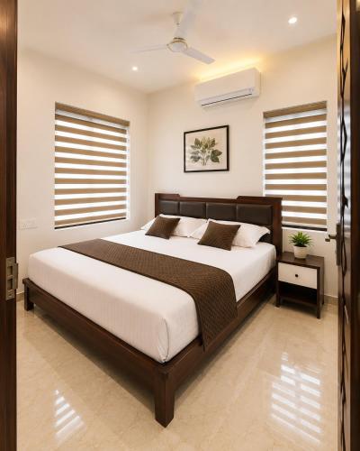 a bedroom with a large bed and two windows at Sidra Apartments - Spacious 2BHK Family Stay in Nilgiris, Pandalur, Tamil Nadu in Pandalūr
