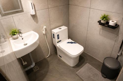 a bathroom with a toilet and a sink at Sidra Apartments - Spacious 2BHK Family Stay in Nilgiris, Pandalur, Tamil Nadu in Pandalūr