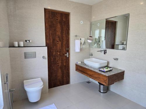 a bathroom with a sink and a toilet and a mirror at Ladakh Himalayan Retreat in Leh