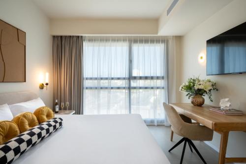 a hotel room with a large bed and a desk at Leonardo Plaza Ashdod in Ashdod