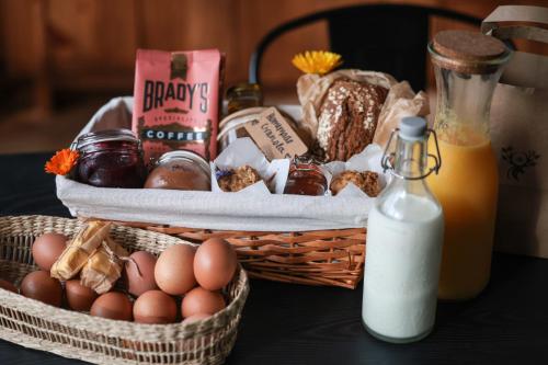 a basket of bread and eggs and a bottle of milk at The Deerstone Luxury Eco Hideaway in Laragh