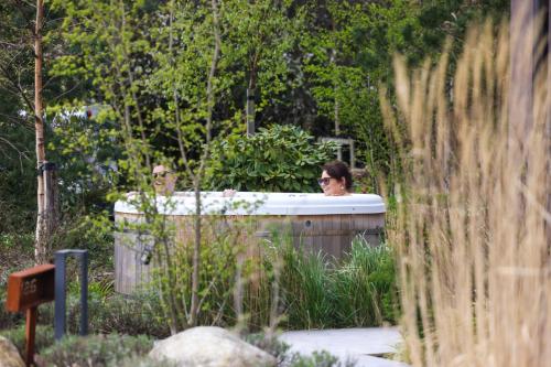 a woman in a bath tub in a garden at The Deerstone Luxury Eco Hideaway in Laragh