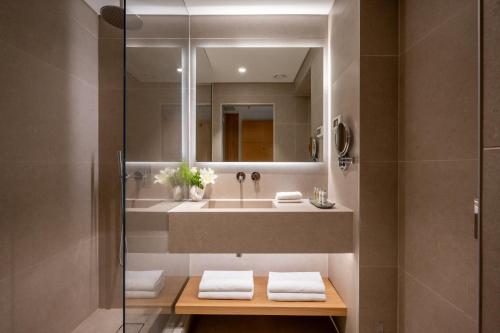 a bathroom with a sink and a mirror at Leonardo Plaza Ashdod in Ashdod