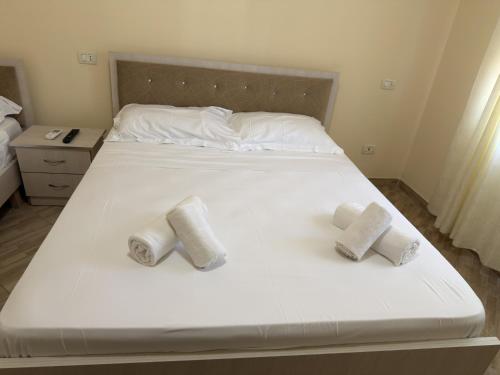 a white bed with three towels on it at Blue Shore in Golem