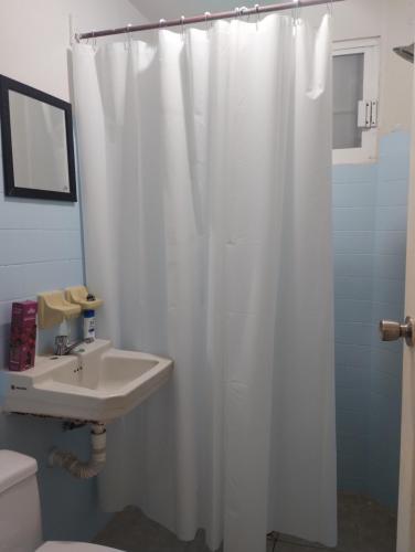 a bathroom with a white shower curtain and a sink at Casa céntrica amplia en Veracruz in Veracruz