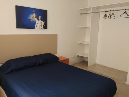 a bedroom with a blue bed and a tv on the wall at Casa céntrica amplia en Veracruz in Veracruz