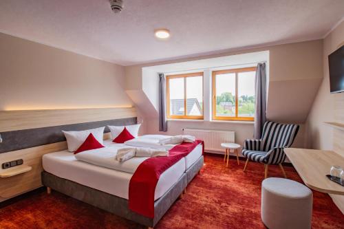 a hotel room with a large bed and a desk at Hotel Lengenfelder Hof in Lengenfeld