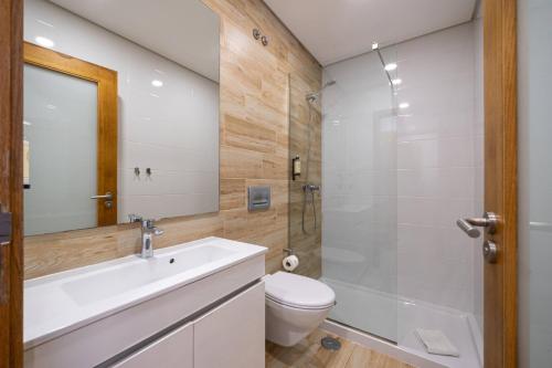 a bathroom with a sink and a toilet and a shower at Central Suítes 1 in São João da Madeira