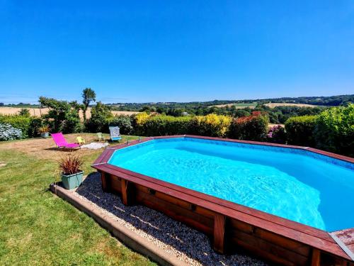 a large swimming pool in a yard with a lawn at une nuit insolite en 1980 in Crédin