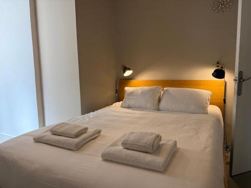 a large white bed with two towels on it at Piso Bonaire in Sitges