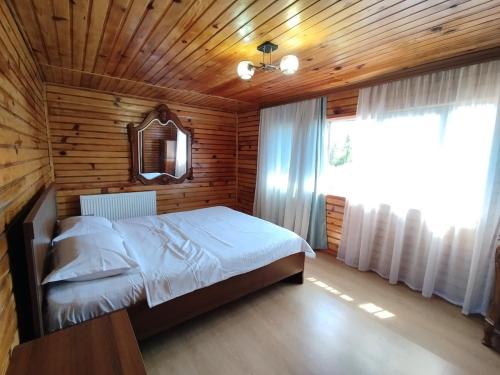 a bedroom with a bed in a wooden room at Entire 4th Floor for Guests in Batumi