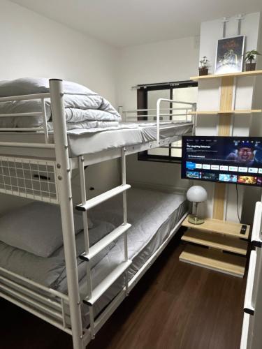 a bunk bed in a room with a computer monitor at COMMA House 川崎 in Kawasaki