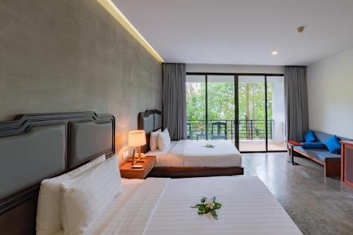 a hotel room with a bed and a balcony at Tanei Angkor Resort and Spa in Siem Reap