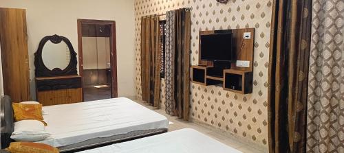 a room with a bed and a tv on a wall at Prithviraj palace in Shahdol