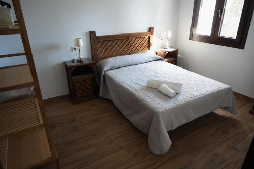 a bedroom with a bed with a white blanket at Alpujarra Las Lindes in Pórtugos