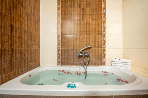 a bath tub with a faucet in a bathroom at Abirami Residency in Pondicherry