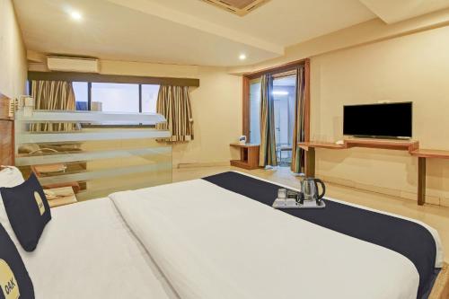 a hotel room with a bed and a tv at Hotel O New Pride in Sāngli