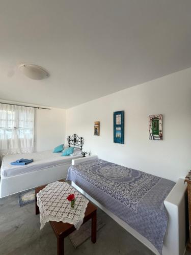 a bedroom with two beds and a table at Hector -Sweet home with a beautiful view in Agia Marina