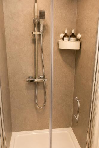 a shower with a glass door in a bathroom at Lavina by the sea in Bangor