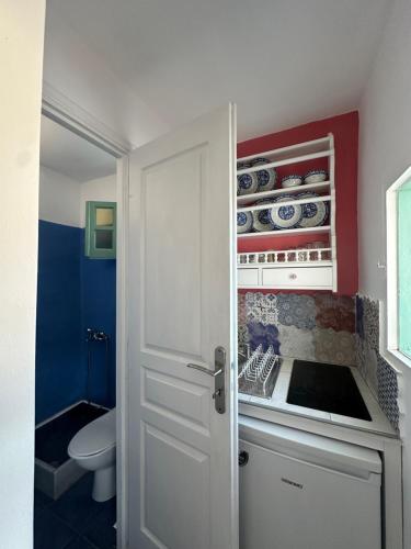 a kitchen with a sink and a white door at Hector -Sweet home with a beautiful view in Agia Marina