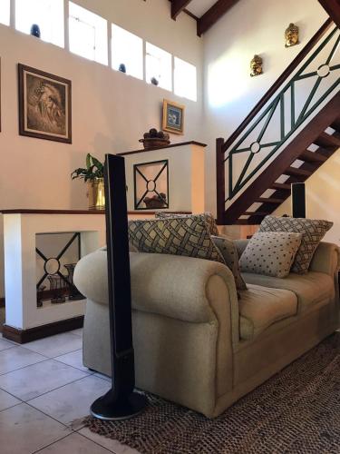 a living room with a couch and a staircase at Executive Serviced Home in Johannesburg