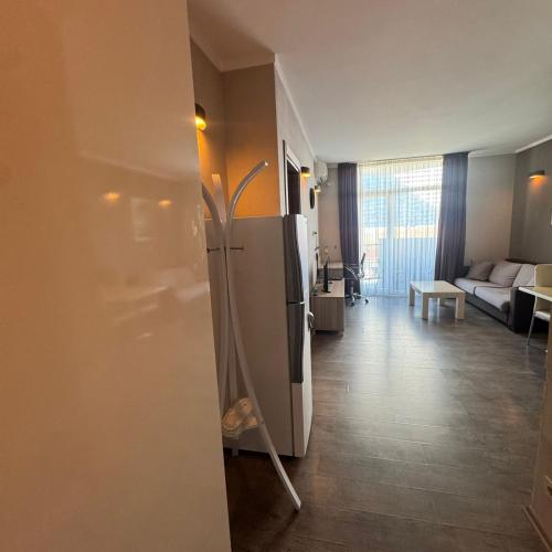 a kitchen with a refrigerator and a living room at Selfie in Batumi