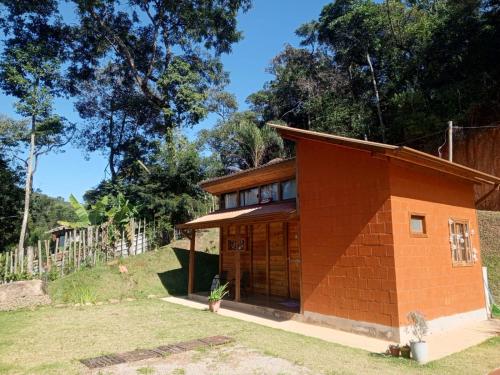 a small brick building with trees in the background at Chalé da Montanha in São Roque