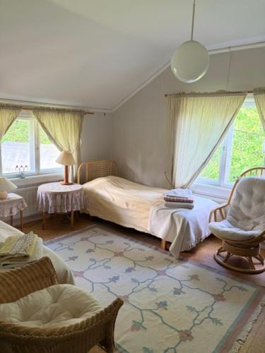 a bedroom with two beds and a chair and windows at Kunnarainen in Sudsaloö