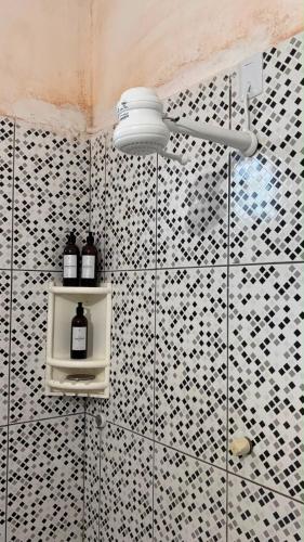 a bathroom with a shower with black and white tiles at Suite casal na praia do Preá in Cruz
