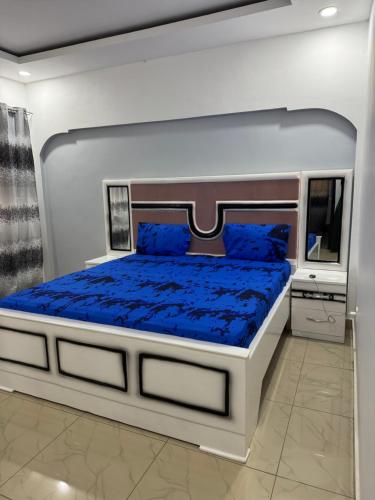 a bedroom with a large bed with blue sheets at Mitty Residence in Conakry