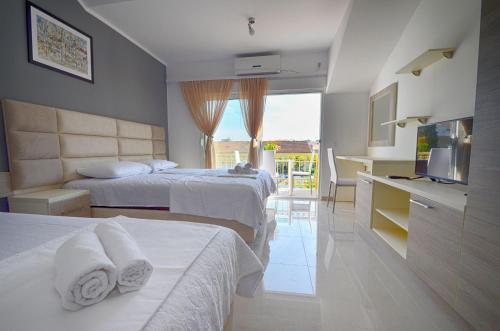 a hotel room with two beds and a television at Villa Velzon Lux in Budva