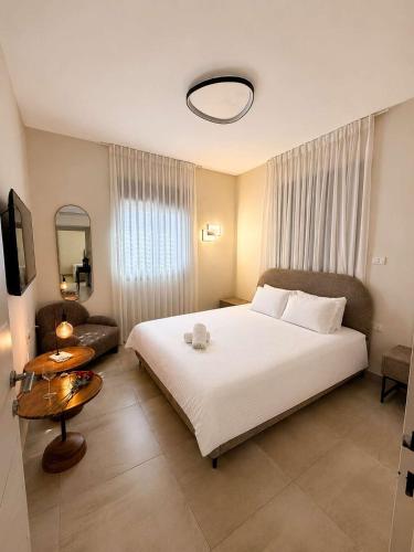 a bedroom with a large white bed and a couch at Villa Naama in Qasrîne