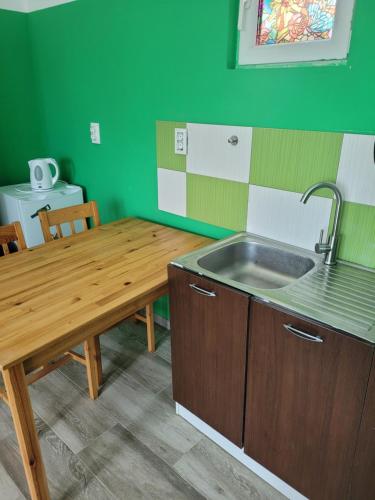 a kitchen with a wooden table and a sink at Căsuța de vacanță in Eforie Sud