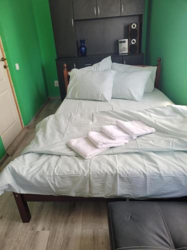 a white bed with two folded towels on it at Căsuța de vacanță in Eforie Sud