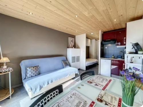 a living room with a couch and a table at Studio montagne Les Carroz in Arâches-la-Frasse