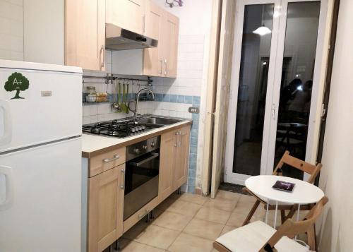 eine kleine Küche mit einem weißen Kühlschrank und einem Tisch in der Unterkunft B&B Amedeo in Neapel