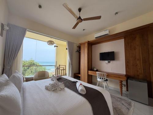 a bedroom with a bed and a large window at Mora Mila in Arugam Bay