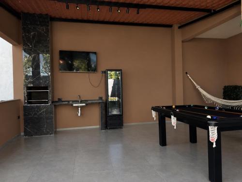 a room with a ping pong table and a hammock at Caminho do mar in Itanhaém