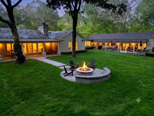 a backyard with a fire pit in the grass at Audubon Acres l pool table & outdoor dining in Benton Harbor