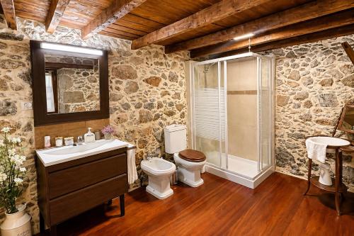 a stone bathroom with a toilet and a shower at Casa Luna - Agüimes in Agüimes